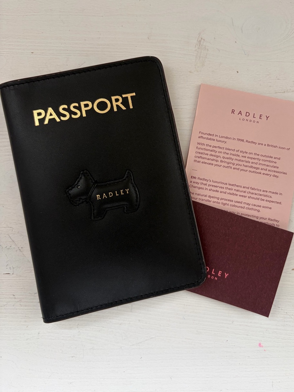 Radley London black leather passport cover features an embossed gold "PASSPORT"